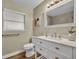 Well lit bathroom with wood floor, toilet, shower view in the mirror and a vanity with storage at 1416 E 20Th St, Sanford, FL 32771