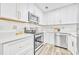 Well-lit kitchen with stainless steel appliances, white cabinets and countertops, and modern backsplash at 1416 E 20Th St, Sanford, FL 32771