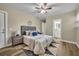 This is a well lit main bedroom with ceiling fan, wood floor, and a view to the bathroom at 1416 E 20Th St, Sanford, FL 32771