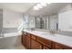 A clean bathroom featuring double sinks, a large mirror, and a separate tub and shower at 14554 Black Cherry Trl, Winter Garden, FL 34787