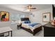 A cozy bedroom with a large window, ceiling fan, and dark wood furniture at 14554 Black Cherry Trl, Winter Garden, FL 34787