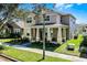 Charming two-story home featuring a welcoming front porch with large columns and lush landscaping at 14554 Black Cherry Trl, Winter Garden, FL 34787