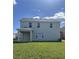 Back exterior view of the home, highlighting a covered patio and spacious yard at 14734 Erice Ave, Clermont, FL 34714