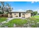 Cozy home featuring a spacious backyard with mature trees and a charming patio area at 1622 Dolphin Dr, St Cloud, FL 34771