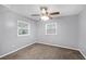 Bedroom with two windows and ceiling fan, gray painted walls, and neutral color carpet floors at 1622 Dolphin Dr, St Cloud, FL 34771