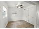 A well-lit bedroom features a ceiling fan, tile floors, two windows and white walls at 1622 Dolphin Dr, St Cloud, FL 34771