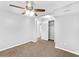 Large bedroom with a ceiling fan, closet, carpet flooring, and view of a hallway at 1622 Dolphin Dr, St Cloud, FL 34771