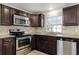 Close-up of the kitchen area featuring stainless steel appliances, granite countertops, and tile backsplash at 1622 Dolphin Dr, St Cloud, FL 34771