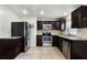 Modern kitchen featuring stainless steel appliances, granite counters, tile backsplash, and rich dark cabinetry at 1622 Dolphin Dr, St Cloud, FL 34771