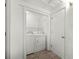 Bright laundry closet featuring tile floors and a stacked washer and dryer with storage shelves at 1622 Dolphin Dr, St Cloud, FL 34771