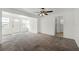 Bright living room with neutral carpet, ceiling fan, and a view to the front door and tiled laundry room at 1622 Dolphin Dr, St Cloud, FL 34771