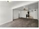 Open living room with neutral carpet and a view into the kitchen featuring dark cabinets and stainless appliances at 1622 Dolphin Dr, St Cloud, FL 34771