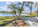 Lush backyard with palm trees, a serene lake view, and a charming dock perfect for enjoying waterfront living at 184 Dublin Dr, Lake Mary, FL 32746