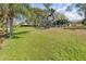 Expansive lawn leading to a serene lake, complemented by mature trees and an inviting screened lanai at 184 Dublin Dr, Lake Mary, FL 32746