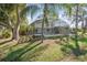 Backyard view of the screened-in pool, mature trees, and well-maintained lawn for outdoor enjoyment and relaxation at 184 Dublin Dr, Lake Mary, FL 32746