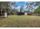 Large, grassy backyard with a screened-in porch, perfect for relaxation and outdoor activities at 200 Avenue C, Chuluota, FL 32766