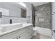 Modern bathroom with a large vanity, tiled shower-tub, and sleek fixtures, exuding elegance and functionality at 2073 Home Again Rd, Apopka, FL 32712