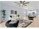 Spacious living room featuring sleek furnishings, fan, and access to the kitchen at 2073 Home Again Rd, Apopka, FL 32712