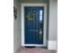 Stylish blue front door featuring a decorative wreath and side window, enhancing curb appeal at 2475 Verde View Dr, Apopka, FL 32703