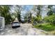 View of the cluttered front yard with multiple vehicles parked on the property and overgrown foliage at 2516 Cannon St, Lakeland, FL 33815