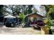 Angle view of the cluttered front yard with multiple vehicles and debris at 2516 Cannon St, Lakeland, FL 33815