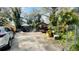 Wide view of a cluttered front yard with vehicles and overgrown foliage at 2516 Cannon St, Lakeland, FL 33815