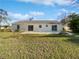 Wide backyard featuring a large green lawn and sliding glass doors to the home at 2720 Settlers Trl, St Cloud, FL 34772