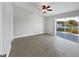 Bright bedroom with neutral walls, ceiling fan, tile floors and sliding glass doors to a lake view at 2720 Settlers Trl, St Cloud, FL 34772