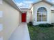 Charming home featuring a vibrant red front door and a well-lit entryway at 2720 Settlers Trl, St Cloud, FL 34772