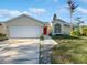 Inviting single-Gathering house featuring a two-car garage and a striking red front door at 2720 Settlers Trl, St Cloud, FL 34772