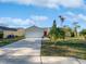 Charming single-story home featuring a white garage door and a vibrant red front door at 2720 Settlers Trl, St Cloud, FL 34772