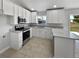 Modern kitchen equipped with white cabinetry, stainless appliances, and granite countertops at 2720 Settlers Trl, St Cloud, FL 34772