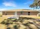 View of the back of the home, with a concrete patio, three windows and siding in neutral color at 30 Hemlock Trce, Ocala, FL 34472