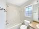 Bright bathroom featuring a shower-tub, white tile surround, window, and neutral wall color at 30 Hemlock Trce, Ocala, FL 34472