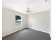 Minimalist bedroom featuring gray carpet, neutral walls, a ceiling fan, and a bright window at 30 Hemlock Trce, Ocala, FL 34472