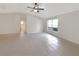 Spacious living room with tile flooring, neutral paint, ceiling fan and bright window at 30 Hemlock Trce, Ocala, FL 34472