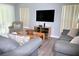 Comfortable living room with a mounted TV, modern sofas, neutral color palette, and light-filled windows at 301 Sandy Ridge Dr, Davenport, FL 33896