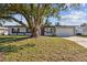 Landscaped front yard with mature tree complements this charming single-story home with attached garage at 3632 E Kaley Ave, Orlando, FL 32812