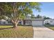 Charming single-story home features a red front door, attached garage and well-maintained front lawn at 3632 E Kaley Ave, Orlando, FL 32812