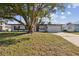 Landscaped front yard with mature tree complements this charming single-story home with attached garage at 3632 E Kaley Ave, Orlando, FL 32812