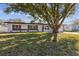 Large shade tree in front of this single-story home with red front door at 3632 E Kaley Ave, Orlando, FL 32812