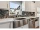 Close-up of a stylish kitchen featuring a stainless steel sink, modern faucet, and a contemporary backsplash at 3632 E Kaley Ave, Orlando, FL 32812