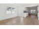 Bright living room featuring light wood floors and an opening to the kitchen with modern white cabinetry at 3632 E Kaley Ave, Orlando, FL 32812