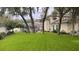 Wide green backyard with covered pool in the background, perfect for outdoor activities at 382 Raleigh Pl, Oviedo, FL 32765