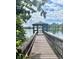 Covered gazebo on a pier over the water surrounded by beautiful trees and clear blue sky at 382 Raleigh Pl, Oviedo, FL 32765