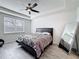 Bedroom features a black bed frame, tray ceilings with ceiling fan, and gray wood floors at 5311 Brydon Woods Cir, St Cloud, FL 34771