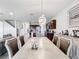 Open floor plan of dining room leading into kitchen with an eat-in island, modern lighting, and gray wood floors at 5311 Brydon Woods Cir, St Cloud, FL 34771