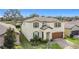 Inviting home featuring manicured lawn, two-car garage, neutral facade with dark shutters against a blue sky at 5311 Brydon Woods Cir, St Cloud, FL 34771