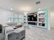 Open living room with gray sectional couch, decorative stone wall and shelving, and a mounted television at 5311 Brydon Woods Cir, St Cloud, FL 34771