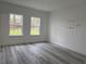 Bright bedroom with gray wood-look floors, two large windows, and decorative wall art at 538 Marion Oaks Blvd, Ocala, FL 34473